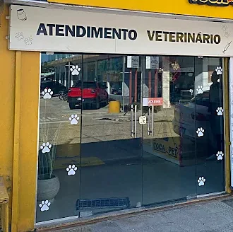 Porta de vidro da Toca do Pet com a placa Atendimento Veterinário